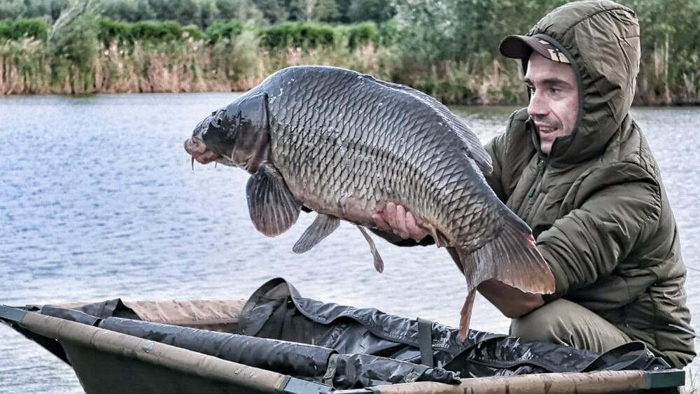 Wędkarz z dorodnym karpiem na łódce nad Big Fish Lake